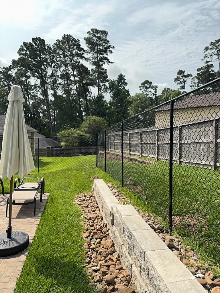 Black chain link fence along a backyard patio