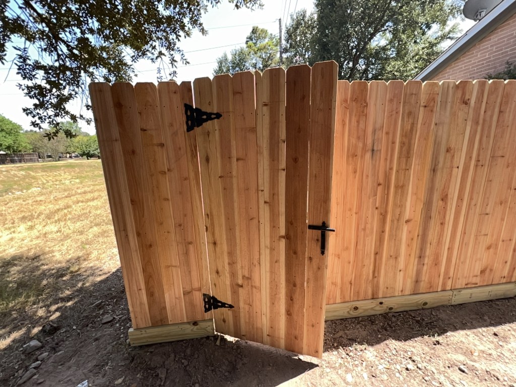 Cedar wood privacy fence with gate installed in a Houston-area backyard